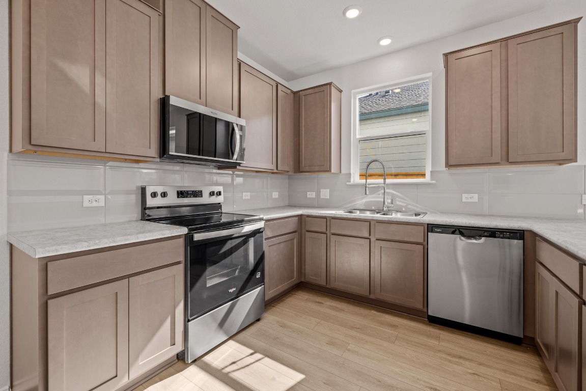 161 Lucky Texan Road Jarrell, TX 76537 - Photo 10 of 32 a kitchen with stainless steel appliances granite countertop a sink a stove a microwave and cabinets