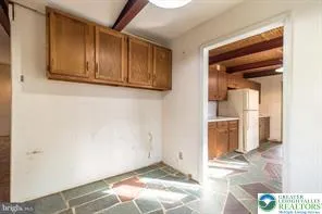 a view of a hallway with wooden floor and a living room