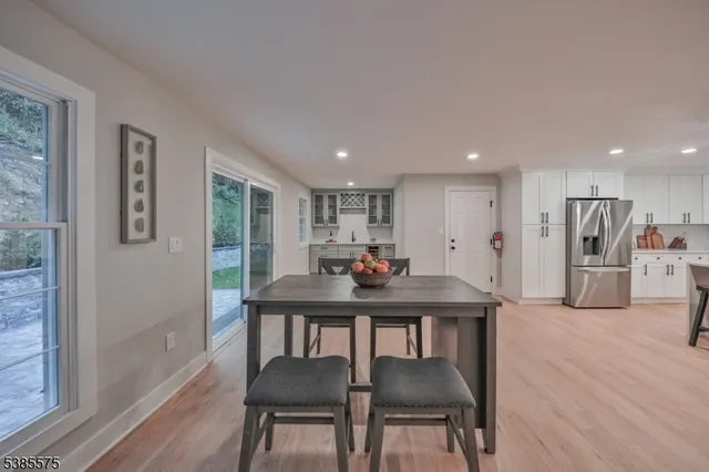 a view of a dining room with furniture a kitchen and chandelier