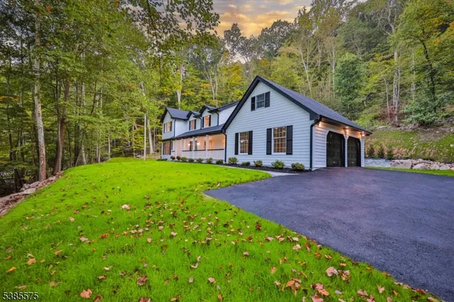 a view of a house with a yard and large tree