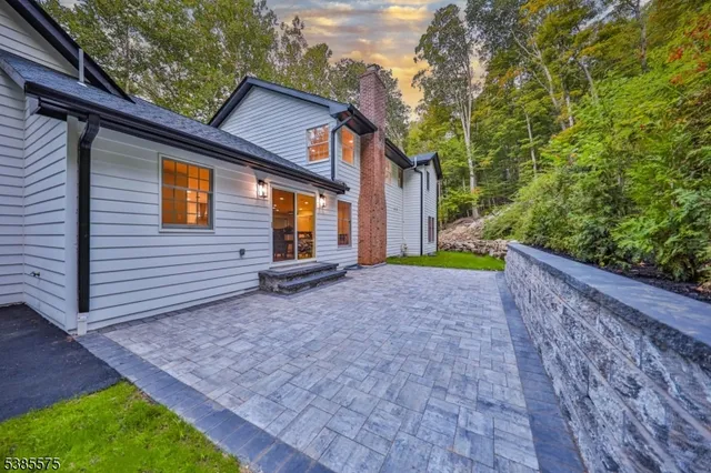 a view of a backyard with plants and large tree