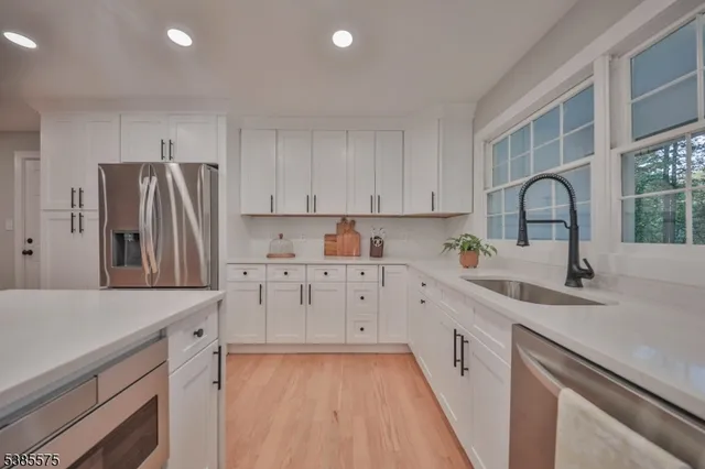 a kitchen with white cabinets and stainless steel appliances