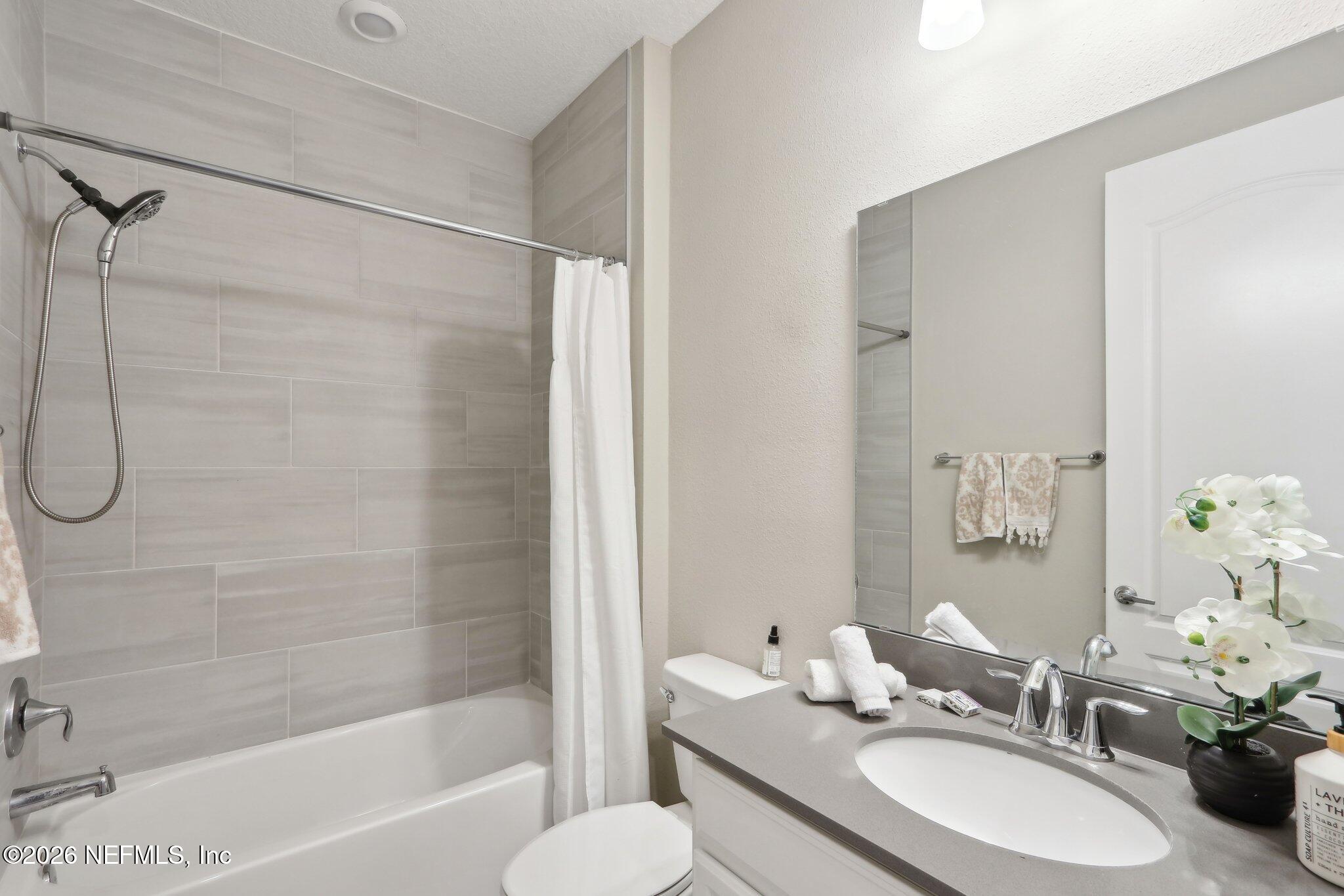 367 Sweet Oak Way St. Augustine, FL 32095 - Photo 17 of 51 a bathroom with a sink vanity mirror and a bathtub