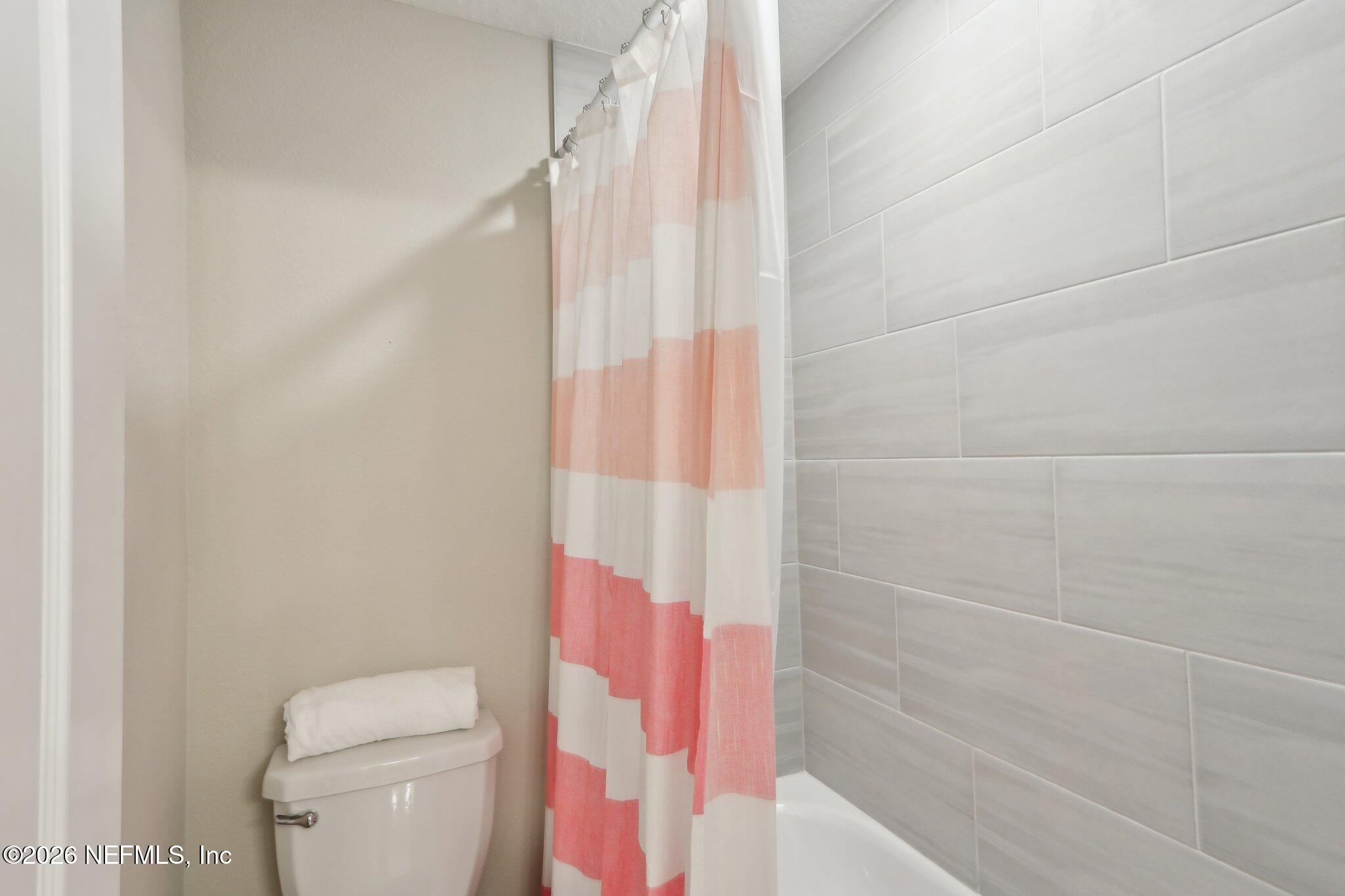 367 Sweet Oak Way St. Augustine, FL 32095 - Photo 21 of 51 a bathroom with a shower curtain and a toilet