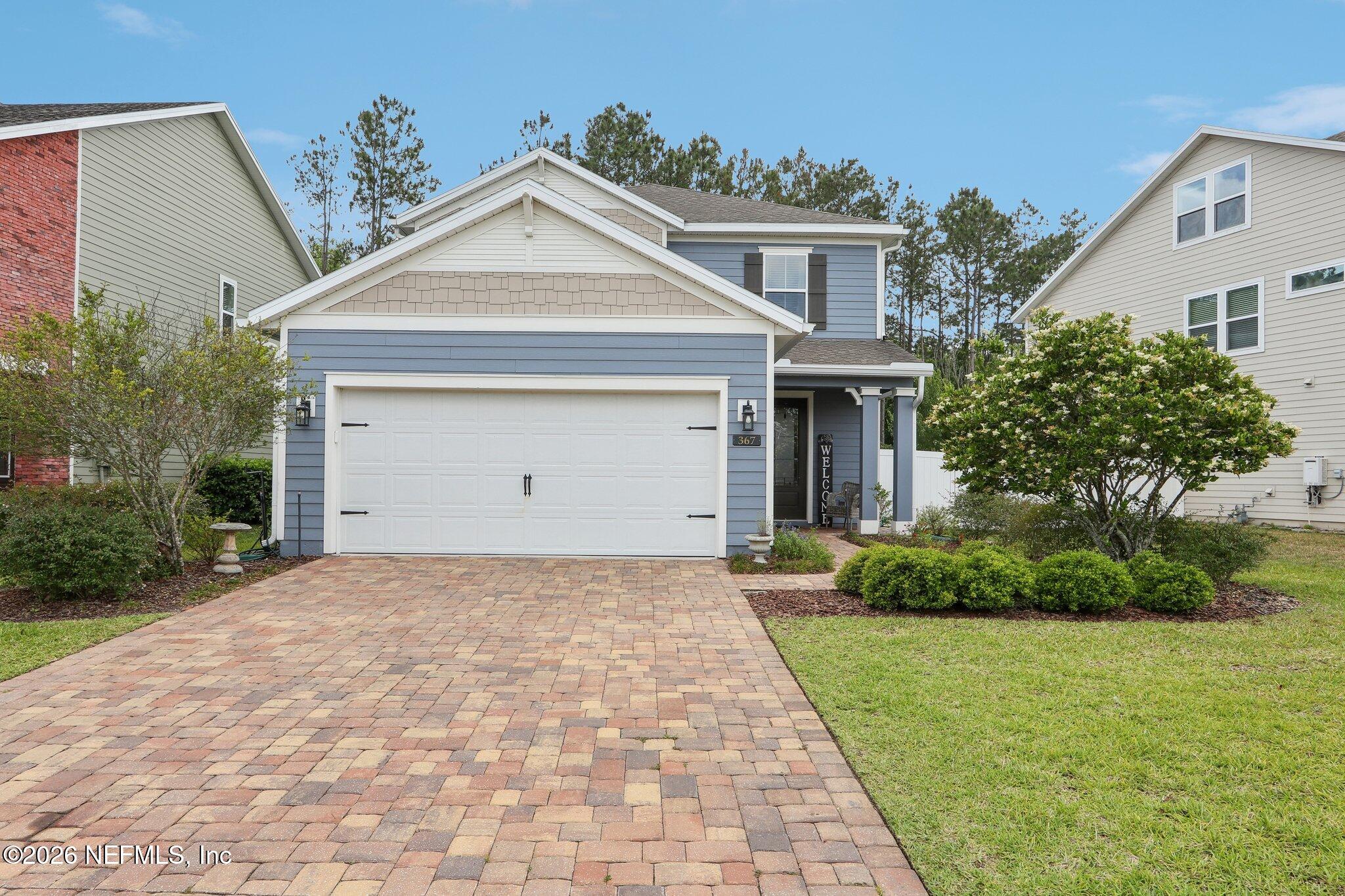 367 Sweet Oak Way St. Augustine, FL 32095 - Photo 3 of 51 a front view of a house with a yard and garage