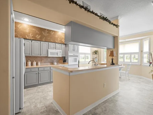 a living room with kitchen island granite countertop furniture and a large window