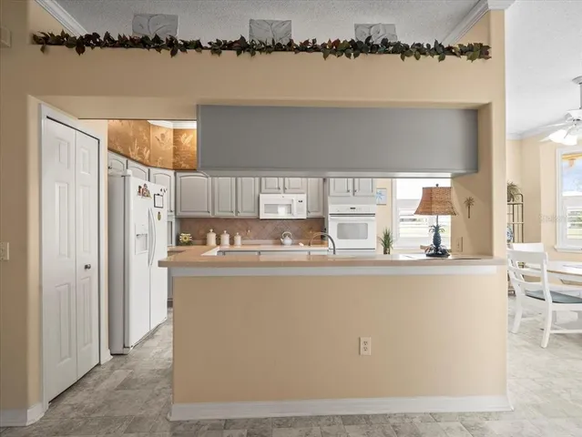 a kitchen with white cabinets and white appliances