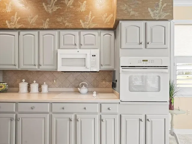 a dining room with furniture a chandelier and a large window