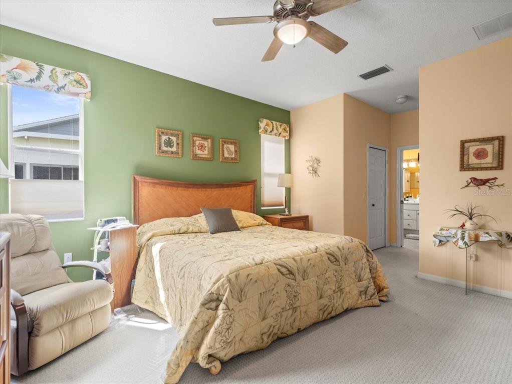 18514 Hidden Pines Way Hudson, FL 34667 - Photo 27 of 57 a bedroom with a bed and ceiling fan