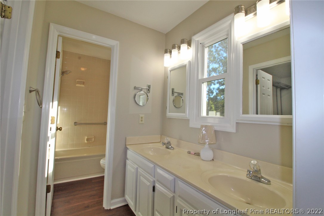 297 Fieldcrest Road Southern Pines, NC 28387 - Photo 17 of 32 a bathroom with a granite countertop sink a mirror and a shower