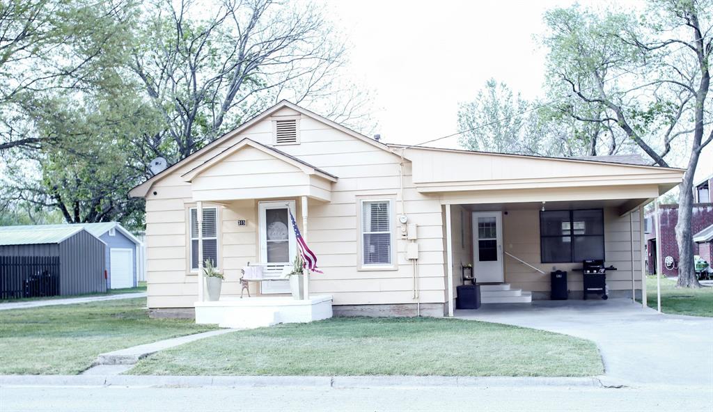 a view of a house with a patio and a yard