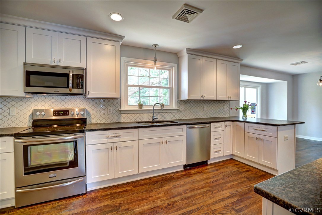10125 Merrimac Road Richmond, VA 23235 - Photo 13 of 25 a kitchen with granite countertop wooden cabinets stainless steel appliances and a window