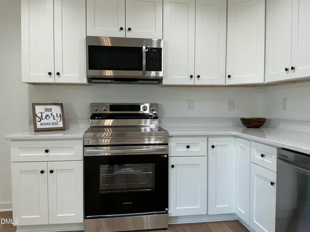 a kitchen with stainless steel appliances granite countertop a stove a microwave and cabinets
