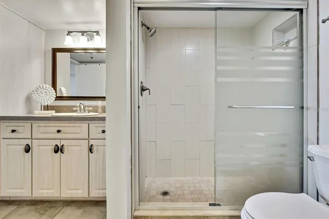 a bathroom with a shower a mirror and a sink