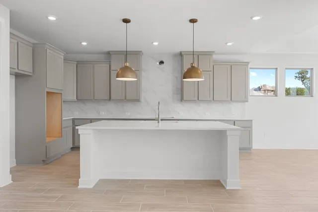 a kitchen with cabinets and wooden floor