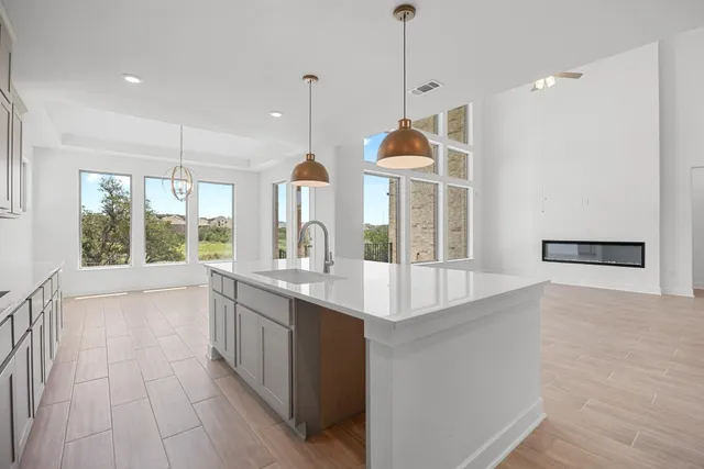 a kitchen with stainless steel appliances granite countertop a sink a oven and a large window