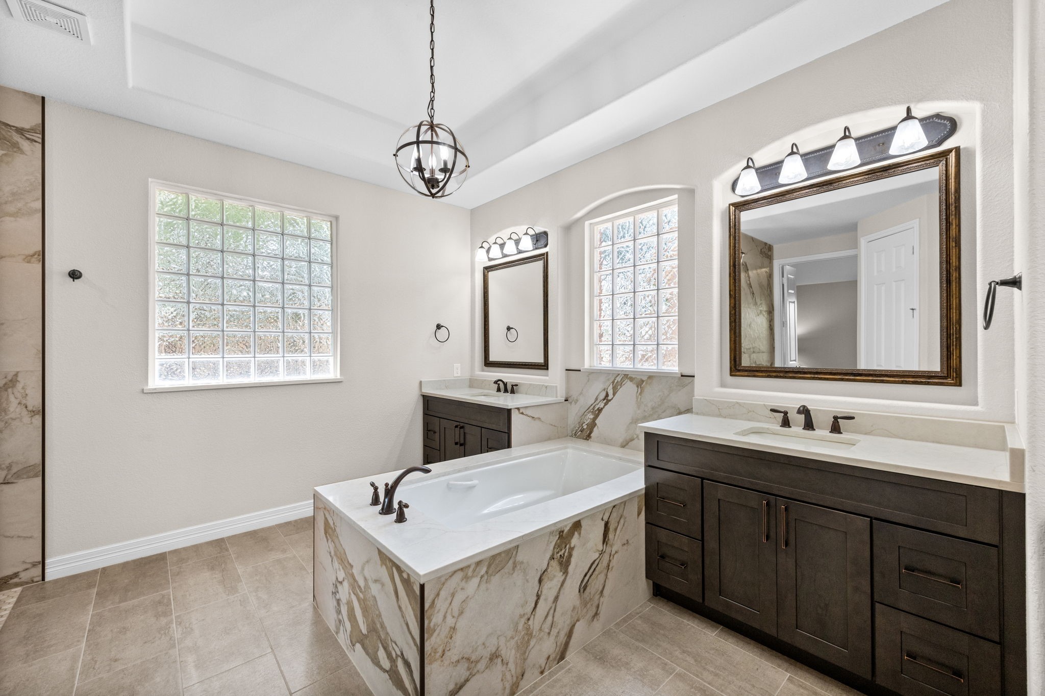 27642 Linden Ridge Lane Fulshear, TX 77441 - Photo 19 of 42 The luxurious Primary Bath features elegant 12x24 tile floors, Quartz countertops, dual vanities with undermount sinks, framed mirrors, widespread oil-rubbed bronze faucets, and coordinating designer light fixtures. This beautifully appointed space blends timeless style with everyday functionality, creating a spa-like retreat.