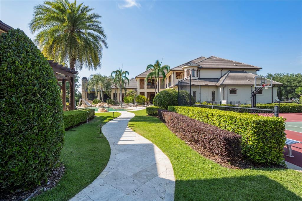 9121 Tibet Pointe Circle Windermere, FL 34786 - Photo 86 of 100 a view of a house with swimming pool and a yard