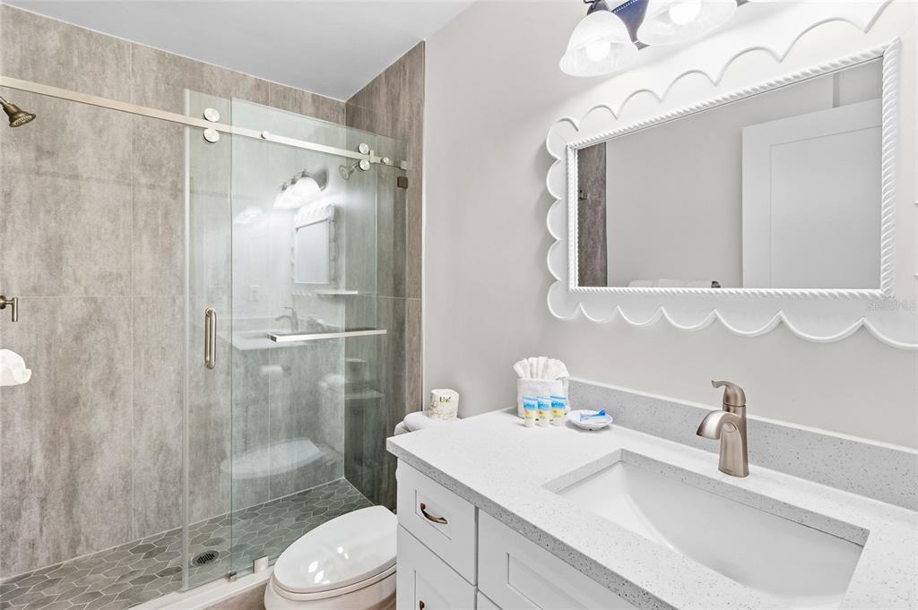 19417 Gulf Boulevard, Unit C109 Indian Rocks Beach, FL 33785 - Photo 13 of 48 a bathroom with a sink toilet a mirror and shower