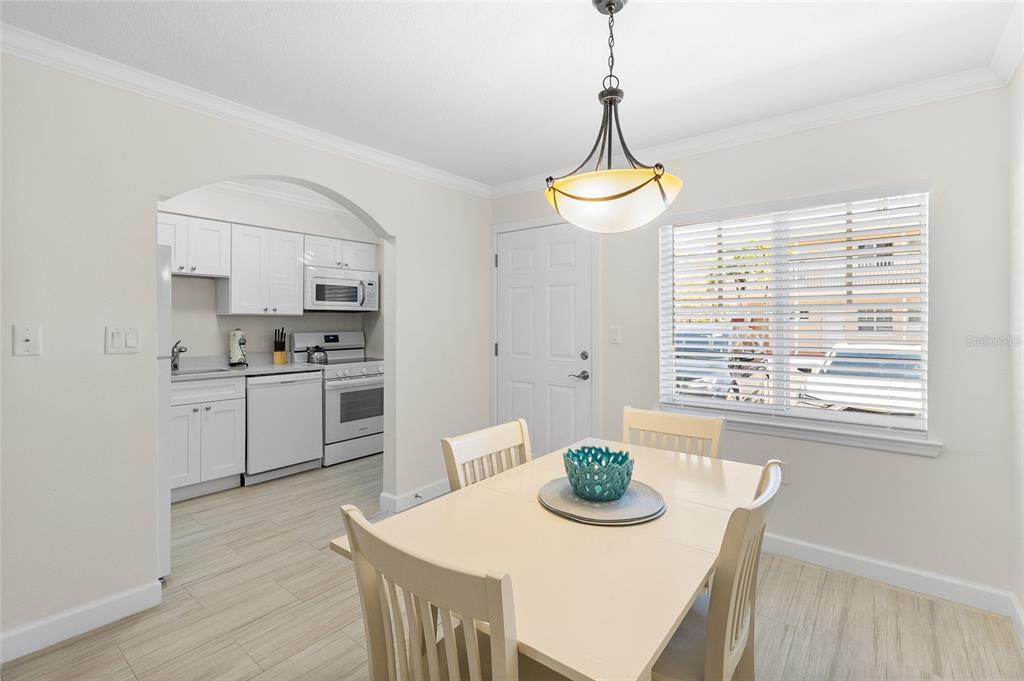 19417 Gulf Boulevard, Unit C109 Indian Rocks Beach, FL 33785 - Photo 25 of 48 a kitchen with stainless steel appliances kitchen island granite countertop a stove a white table and chairs