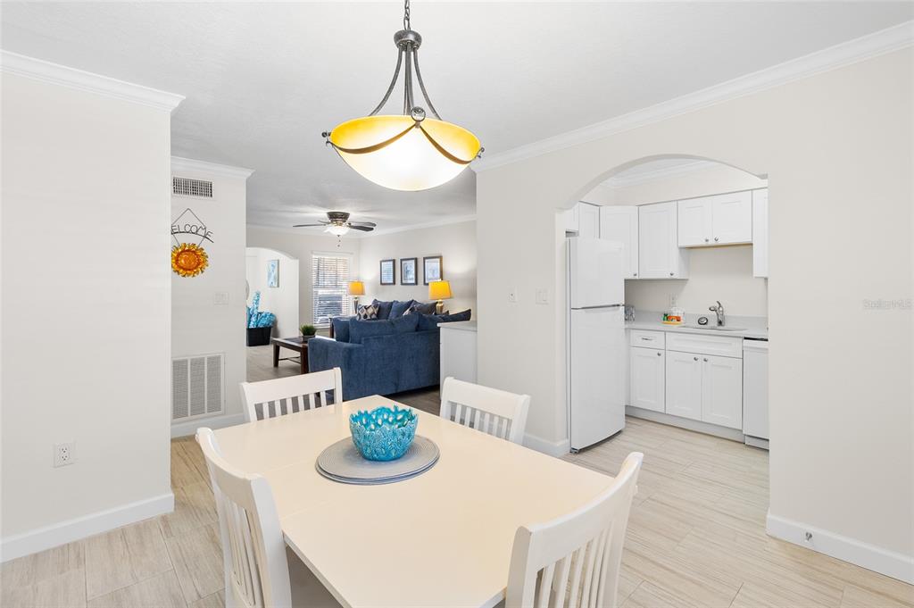 19417 Gulf Boulevard, Unit C109 Indian Rocks Beach, FL 33785 - Photo 26 of 48 a kitchen with stainless steel appliances kitchen island granite countertop a table and chairs in it