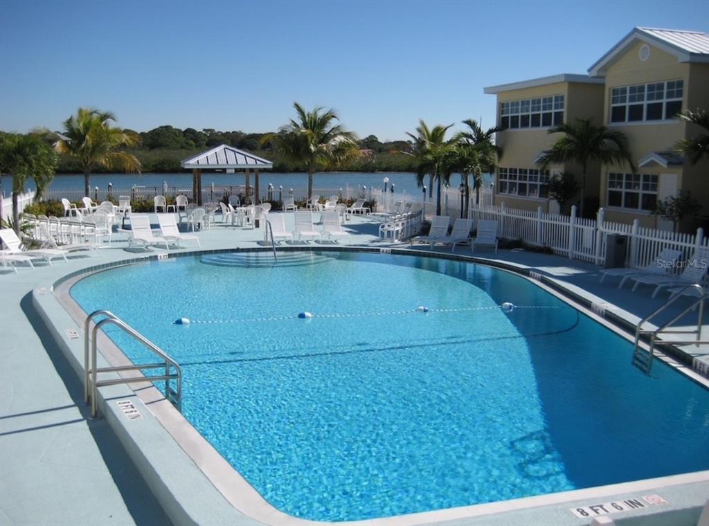 19417 Gulf Boulevard, Unit C109 Indian Rocks Beach, FL 33785 - Photo 46 of 48 a view of a swimming pool with a patio and a garden