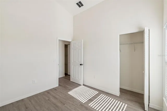 a view of a room with wooden floor and a ceiling fan