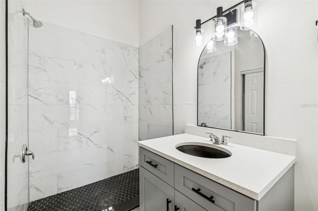 119 Winchester Lane Haines City, FL 33844 - Photo 13 of 24 a bathroom with a sink a mirror and a shower