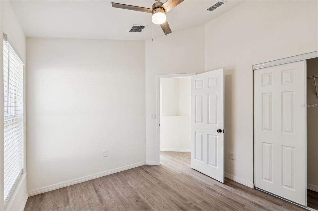 119 Winchester Lane Haines City, FL 33844 - Photo 18 of 24 an empty room with wooden floor fan and windows