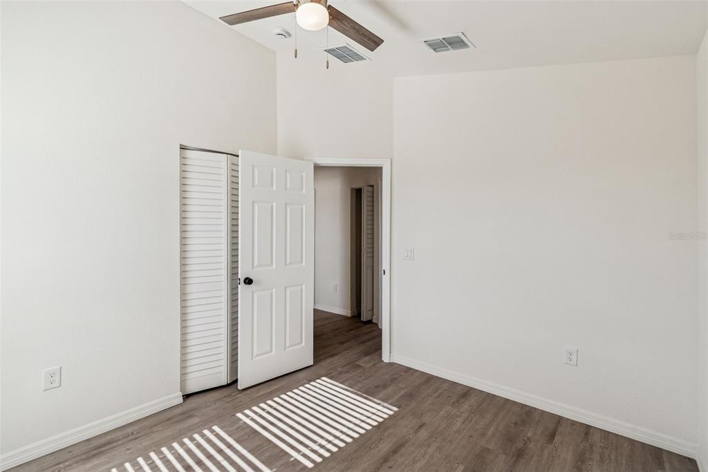 119 Winchester Lane Haines City, FL 33844 - Photo 20 of 24 an empty room with wooden floor cabinet and hallway