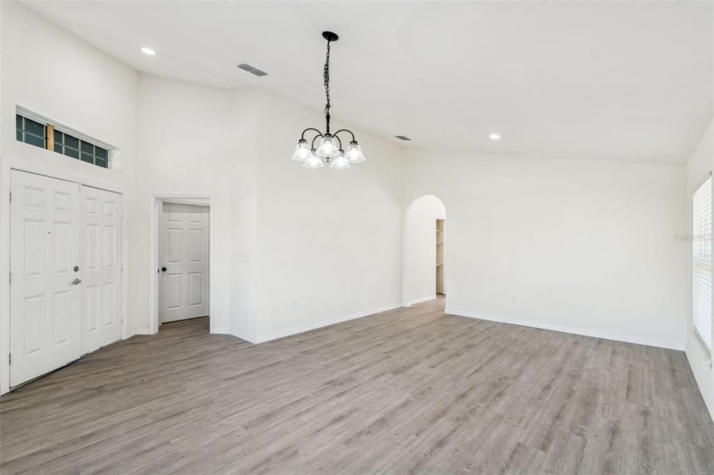 119 Winchester Lane Haines City, FL 33844 - Photo 3 of 24 a view of an empty room with wooden floor and a ceiling fan