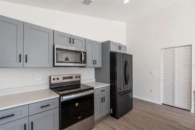 a kitchen with a refrigerator stove and wooden cabinets