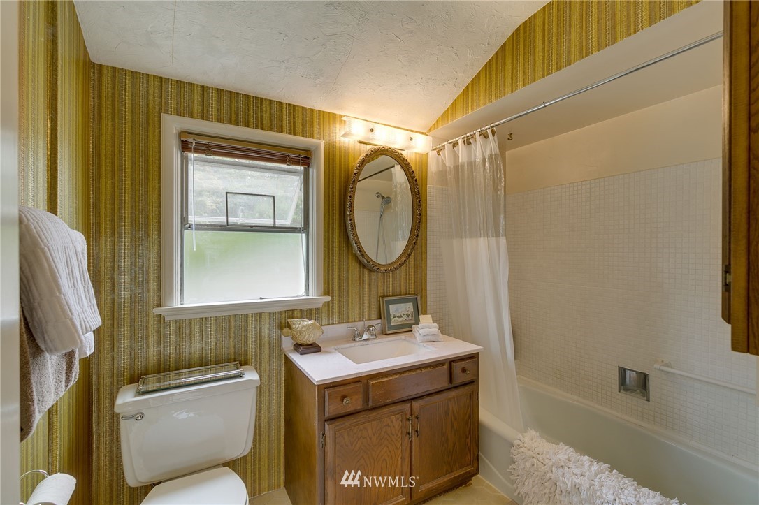 2602 29th Avenue West Seattle, WA 98199 - Photo 21 of 40 a bathroom with a toilet sink vanity tub and mirror