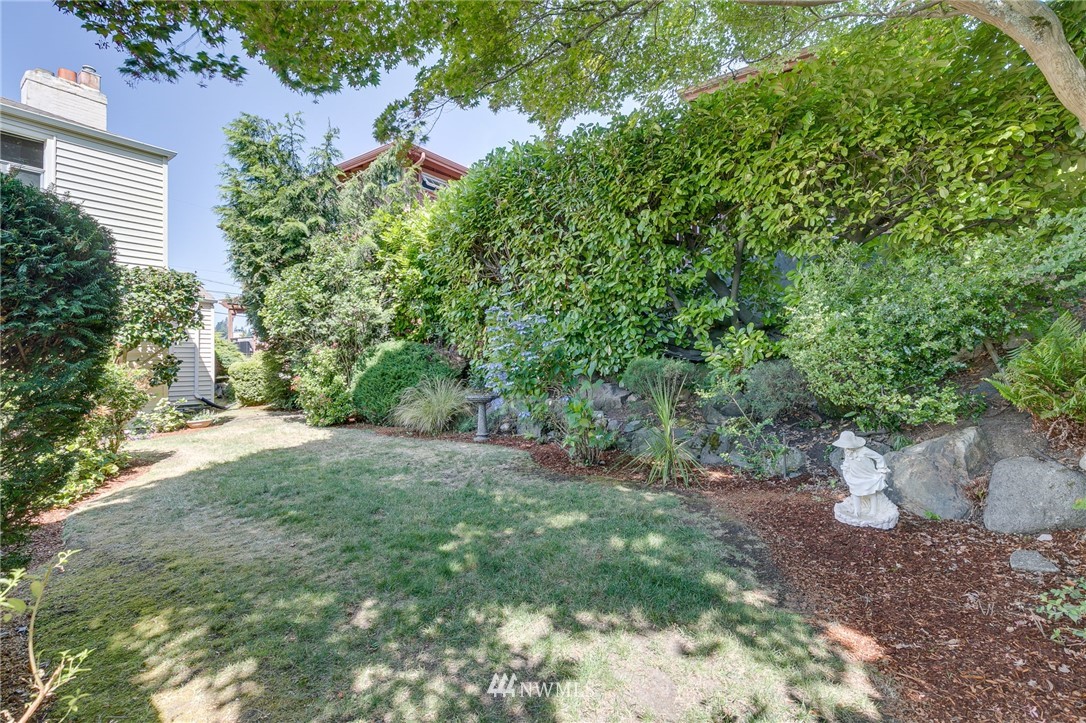 2602 29th Avenue West Seattle, WA 98199 - Photo 32 of 40 a view of a yard with plants and large trees