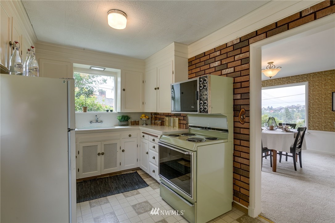 2602 29th Avenue West Seattle, WA 98199 - Photo 9 of 40 a kitchen with a stove sink and cabinets