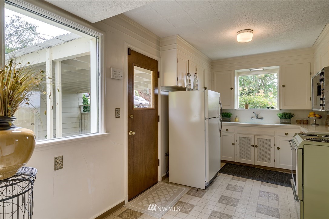2602 29th Avenue West Seattle, WA 98199 - Photo 10 of 40 a kitchen with white cabinets and window