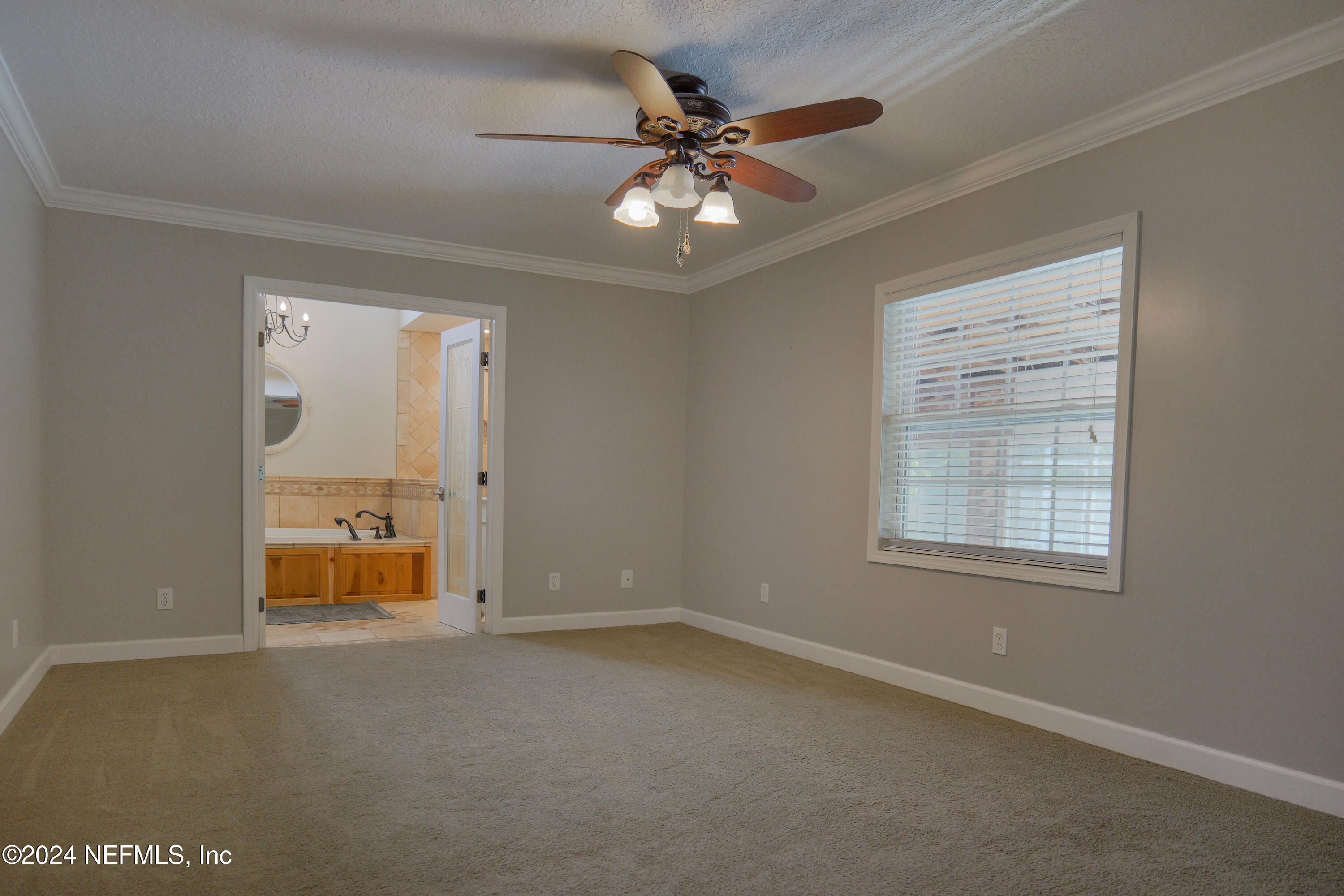 6566 Sherry Lane St. Augustine, FL 32095 - Photo 10 of 24 an empty room with chandelier fan and windows