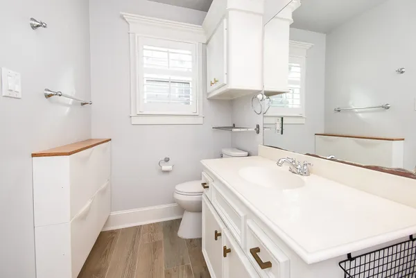 a bathroom with a sink a toilet and a window