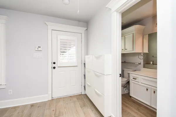 a hallway with white cabinets and wooden floor