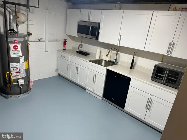 a kitchen with stainless steel appliances a sink a stove a microwave a refrigerator and cabinets