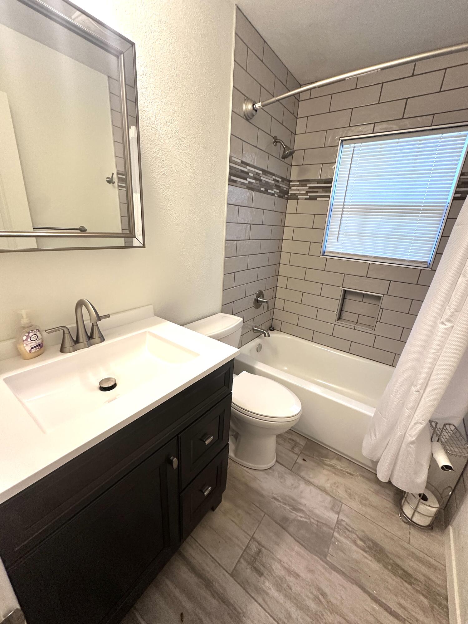 3719 30th Street, Unit A Lubbock, TX 79410 - Photo 12 of 16 a bathroom with a sink mirror vanity and toilet
