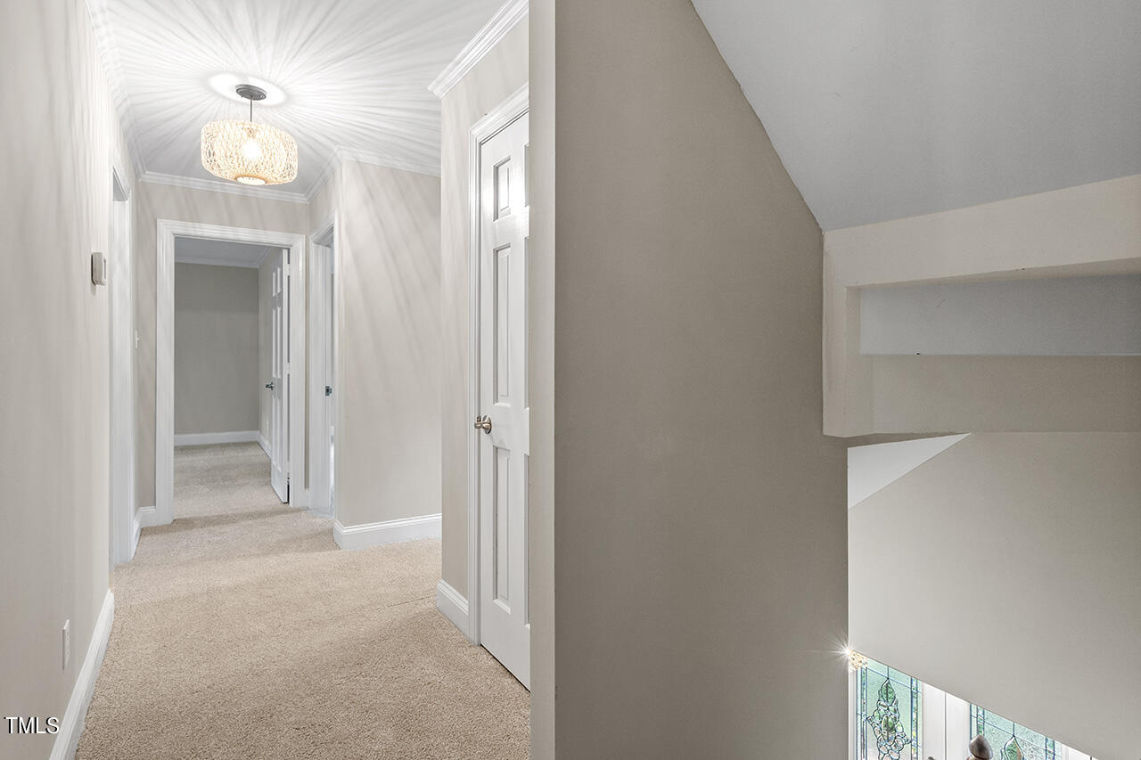 5200 Smallwood Court Raleigh, NC 27613 - Photo 19 of 38 a view of a hallway with wooden floor and a chandelier