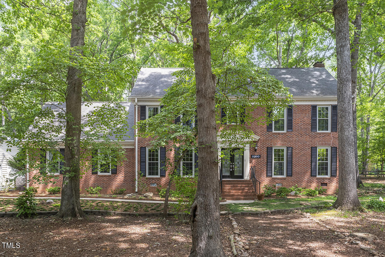 5200 Smallwood Court Raleigh, NC 27613 - Photo 3 of 38 a view of a brick house with a large windows and large tree