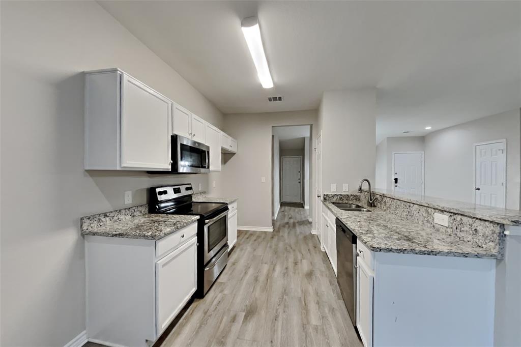 105 Independence Trail Forney, TX 75126 - Photo 4 of 18 a kitchen with stainless steel appliances granite countertop a stove a sink and a microwave