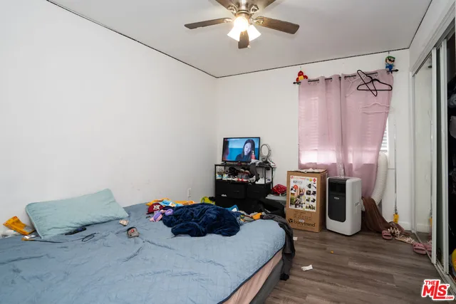 a bedroom with a bed and a flat tv screen on a dresser
