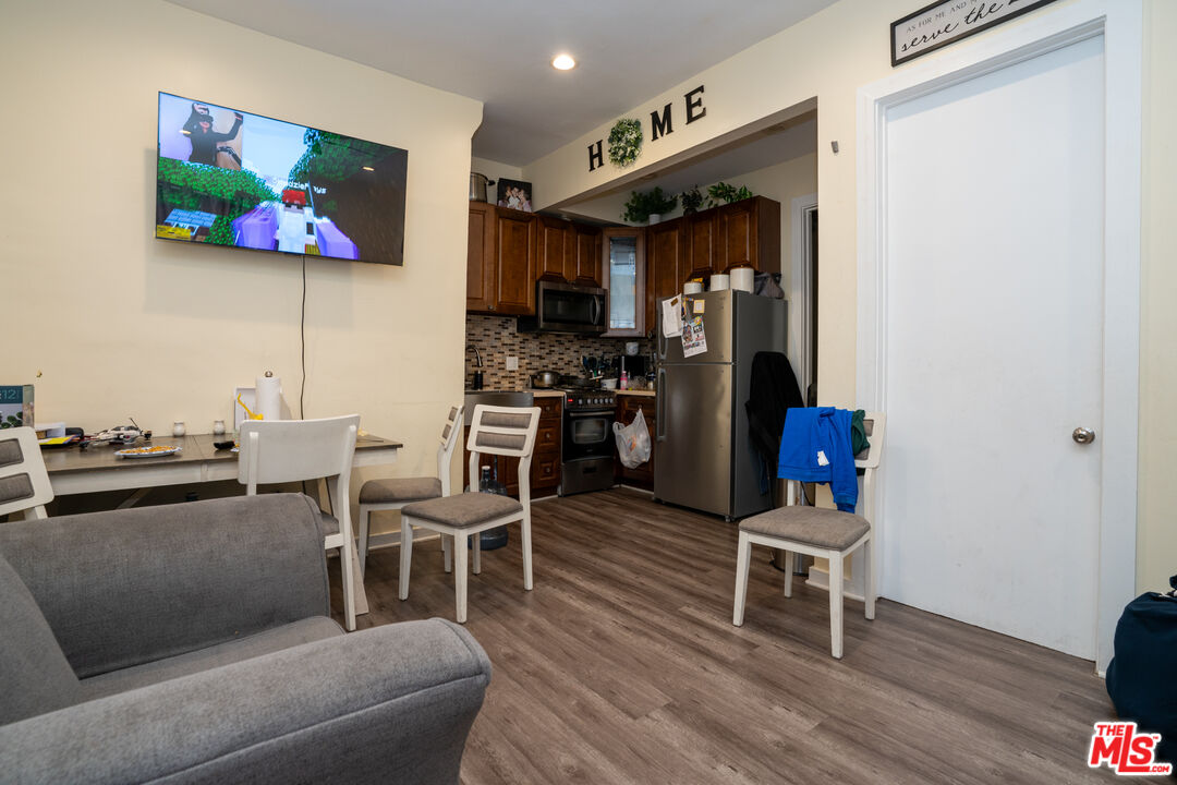 1047 East 33rd Street Los Angeles, CA 90011 - Photo 21 of 24 a living room with furniture a flat screen tv and kitchen view