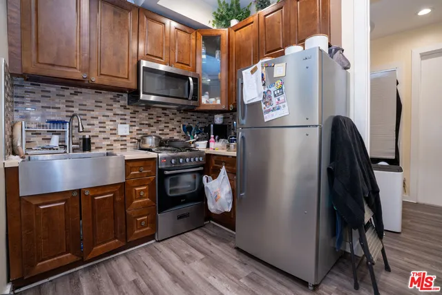 a kitchen with stainless steel appliances granite countertop a refrigerator a stove a sink and dishwasher