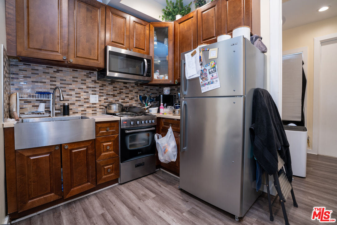 1047 East 33rd Street Los Angeles, CA 90011 - Photo 22 of 24 a kitchen with stainless steel appliances granite countertop a refrigerator a stove a sink and dishwasher
