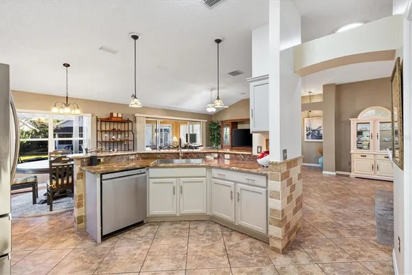 a kitchen with granite countertop a refrigerator stove and microwave