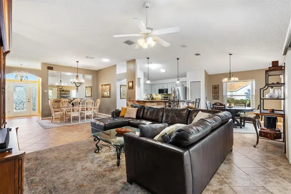 a living room with furniture and a open kitchen view